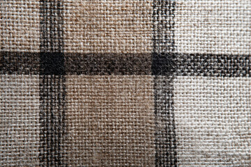 Coarse linen texture plaid pattern beige brown black square grid woven fabric macro rustic textile detail closeup tactile cozy neutral tone craft material background weave