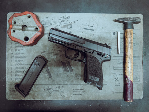 December 22, 2025, Baltic States. Professional German Heckler Koch USP 9mm army pistol on gunsmith workbench for maintenance and sight adjustment.