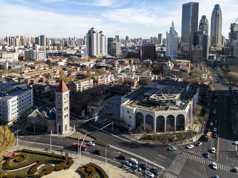Aerial view of the contrasting old clock tower and modern skyscrapers with the city's bustling streets below, Tianjin, Tianjin, China.