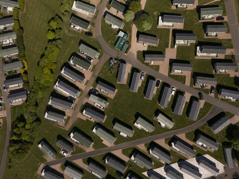 Aerial view of rows of neatly arranged mobile homes with their dark roofs contrasting against the green grass, St Andrews, Scotland, United Kingdom.