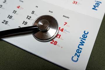 A stethoscope resting on a calendar page featuring June dates, illustrating the importance of health appointments and medical care planning within daily life.