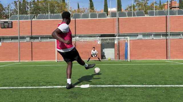 Black soccer player kicking a penalty shootout and missing the goal