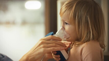 A devoted mother, well-versed in health guidance, gently helps her young daughter operate a nebulizer to alleviate asthma symptoms during a cold. The caring guidance helps manage the child's condition