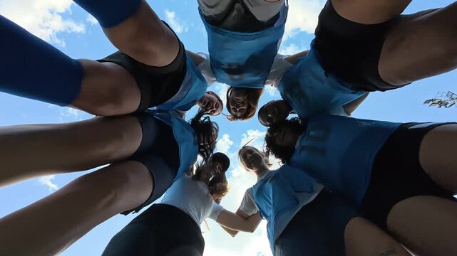 Female soccer team huddle celebrating victory together