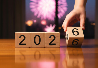 New Years Eve celebration with wooden blocks displaying 2026 in festive fireworks background for calendar design