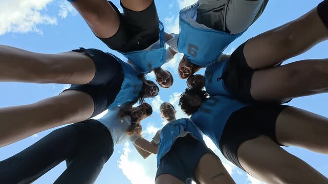 Women's soccer team huddling together in a circle