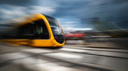 Fototapeta premium Rushing Yellow Tram With A Motion Blur Effect Moves By A City Street In Budapest