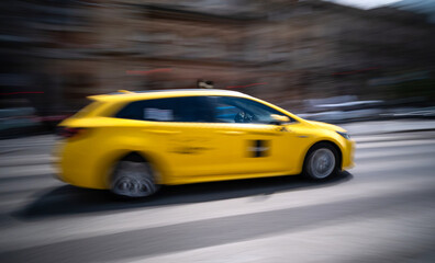 Fototapeta premium Yellow City Taxi Rushes, Blurred In Motion, On The Street