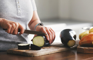 Girl Cutting Eggplant On A Cutting Board For Baking With Other Vegetables