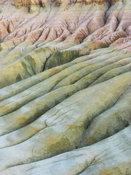 Aerial view of the stunning multi-hued canyons and eroded landscapes, showcasing nature's artistry in soft pinks, greens, and tans, Karynzharyk, Mangystau Region, Kazakhstan.
