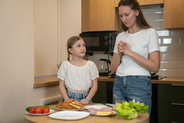 Mother and daughter bonding in a modern kitchen, learning to prepare healthy sandwiches together...