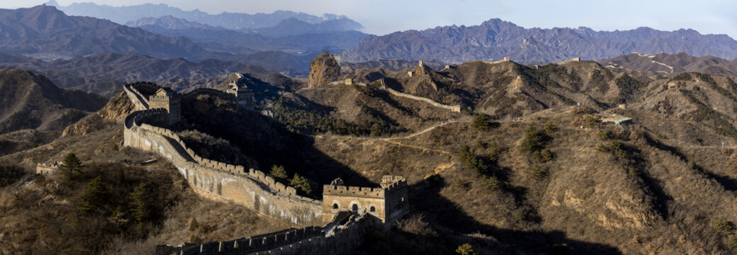 View of the Great Wall snaking across the rugged, mountainous terrain, ancient stone contrasting with the stark, bare landscape, Chengde, Beijing, China.