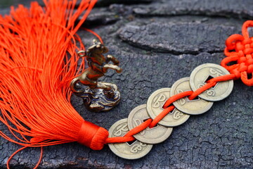 Chinese coins with red threads and a horse figurine.