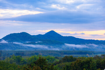 A photograph of the morning sky. Sunrise. Mountain landscape with mist surrounding the mountains.
