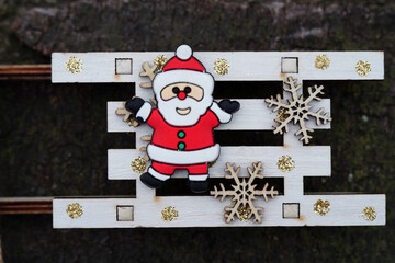 A figurine of a little Santa on a wooden sleigh.