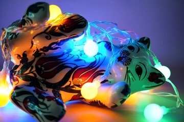 A ceramic toy cat and a glowing Christmas tree garland.