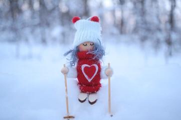 A figurine of an angel on skis in a winter forest.