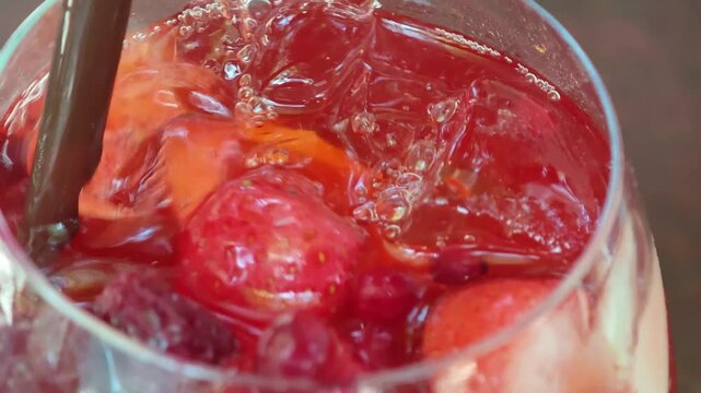 Red berry tea served with a glass of iced mixed fruit.
