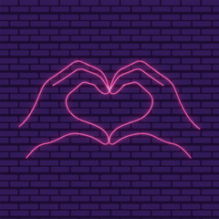 A glowing pink neon heart shape formed by hands against a dark brick wall backdrop and dark background