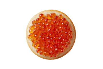 Overhead shot of a circular toast topped with bright orange fish roe on a black background