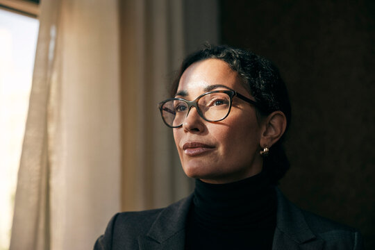 Contemplative female financial advisor wearing eyeglasses looking away