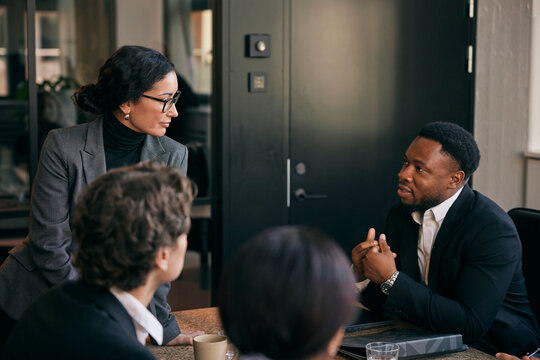 Male business expert talking with female colleague during meeting in law firm