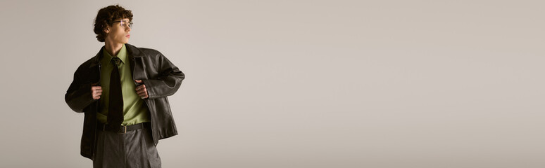 Stylish young man showcases modern fashion in a minimalistic setting