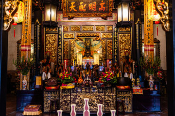 Taipei City, Taiwan - 11 April 2025: View of Dalongdong Baoan Temple's rich, ornate altar glows under lanterns, a symphony of gold carvings and vibrant floral offerings.