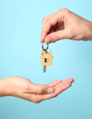 A real estate agent&rsquo;s hand holding a new house model represents a property investment concept for buying or selling a home in the building and loan business