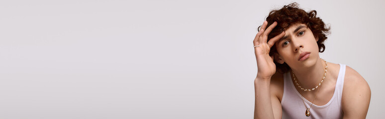 Naklejka premium Stylish young man showcases modern fashion in a minimalist setting with confidence and charm