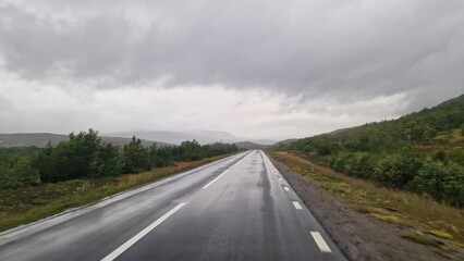 Naklejka premium A road trip through Scandinavia is defined by vast forests, countless lakes, frequent rain, and a strong feeling of wilderness and solitude. The landscape is dominated by boreal forest, calm w