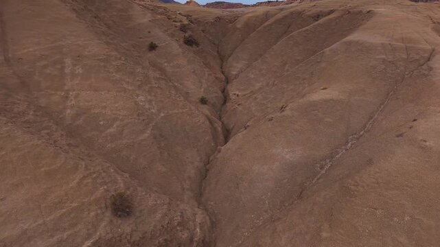 Aerial view of the rugged Calanchi del Cannizzola, its layered earth tones creating a stark, geological tableau, Centuripe, Sicilia, Italy.