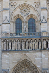 Notre Dame Cathedral facade with sculptures and windows in Paris, France