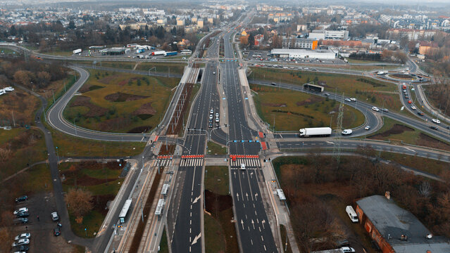 Aerial drone view of multi-lane urban intersection with tram tracks, bus lanes and roundabouts&mdash;modern road infrastructure, traffic signals and landscaped medians, European city, no people