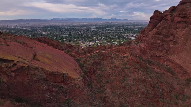 Aerial view of the arid Papago Park, where red rocks meet the bustling cityscape under a pastel sky, Phoenix, Arizona, United States.