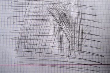 Cross strokes of graphite pencil in notebook