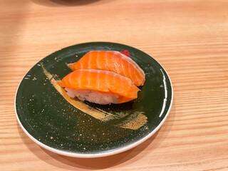 日本の寿司。回転寿司のお皿に乗ったサーモン握り寿司。