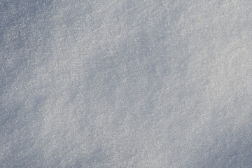 Snow texture. Top view photo of snow on the ground in the sunny winter morning. Winter white pure clean snow background with soft snowflakes on cold day.