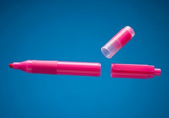 A pink highlighter marker broken into three pieces with the cap floating on a vibrant blue surface