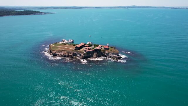 Aerial view of St. Anastasia Island featuring historic buildings and a lighthouse surrounded by the turquoise waters of the Black Sea, St. Anastasia Island, Burgas, Bulgaria.