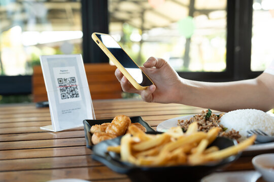 Woman use smartphone to scan QR code to pay in cafe restaurant with a digital payment without cash. Choose menu and order accumulate discount. E wallet, technology, pay online, credit card, bank app.
