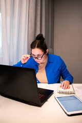 Young entrepreneur developing startup business plan at home. Determined woman working on financial projections. Innovation, business planning, and business startup concept