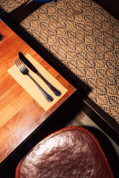 High angle view of knife and fork arranged on side of table in restaurant