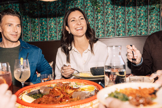 Happy woman having dinner with friends at fine dining restaurant