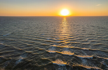 Aerial sunset over sea waves