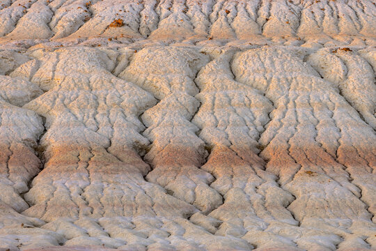 View of earth's raw beauty carved by time, showcasing delicate layers of beige and red, a ground-level perspective, Senek, Mangystau Region, Kazakhstan.