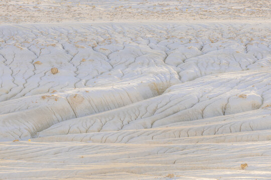 View of bright, sun-baked earth, etched with intricate patterns of erosion, revealing the subtle textures of the arid landscape, Senek, Mangystau Region, Kazakhstan.
