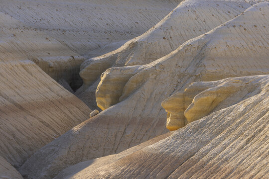 View of undulating, layered rock formations carved by time and weather, displaying a palette of earthy browns and creams, Senek, Mangystau Region, Kazakhstan.