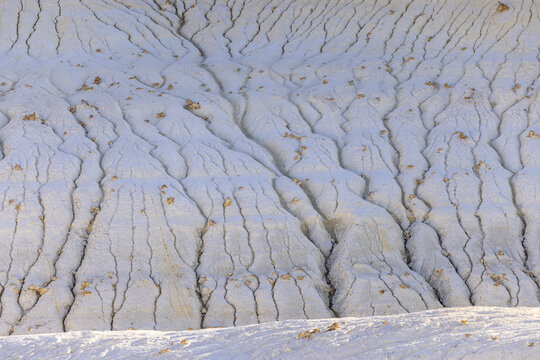 View of the stark, eroded landscape reveals intricate patterns carved into the pale earth, a testament to time and nature's artistry, Senek, Mangystau Region, Kazakhstan.