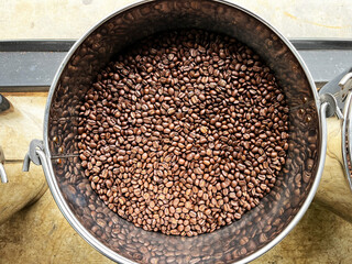Freshly roasted coffee beans cooling inside an industrial coffee roasting drum, showing texture, aroma, and production process for specialty coffee, food industry, and artisanal roasting concepts